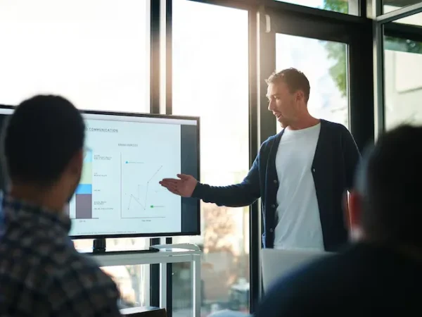 imgi_33_presentacion-hombre-negocios-punto-pantalla-oficina-reunion-grupo-discurso-estrategia-b2b-graficos-orador-persona-e-informacion-tab